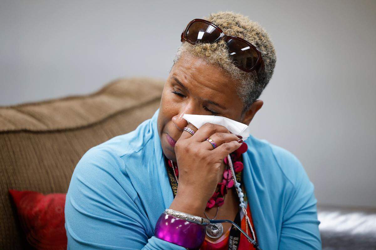 Camille Stephens wipes away tears during a parent talk therapy at Plaza Road Academy in Charlotte. Stephens hosts the therapy session every Thursday for people whose children are in the juvenile justice system.