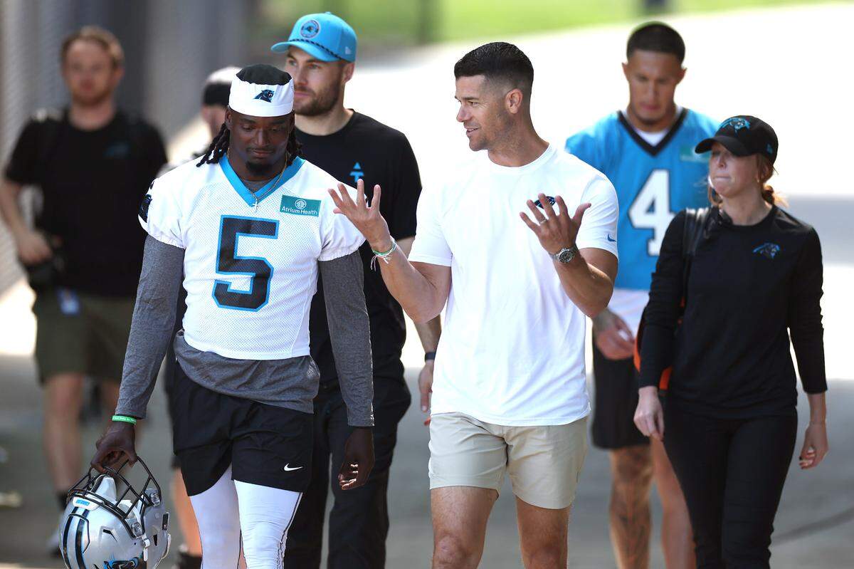 Carolina Panthers head coach Dave Canales, right, talks with cornerback Keion Corseen, left, as they walk to the team’s rookie minicamp practice on Friday, May 9, 2025.