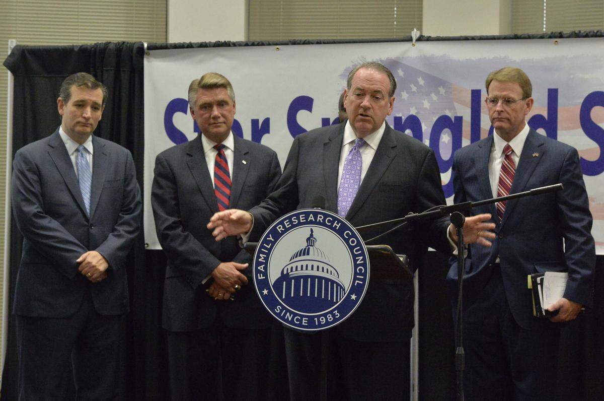 During a press conference Former Governor Mike Huckabee (center, at podium), speaks to the media, (back L-R), Sen. Ted Cruz, Mark Harris,senior pastor, First Baptist Church of Charlotte,Tony Perkins,president,Family Research Council (far right). Two possible contenders for the 2016 Republican presidential nomination were in Charlotte on Sept. 14,2014 to headline “Star Spangled Sunday, “ a live national webcast from First Baptist Church of Charlotte. The Rev. Mark Harris, who pastors First Baptist, said the event celebrating the 200th anniversary of the national anthem, “The Star-Spangled Banner. “