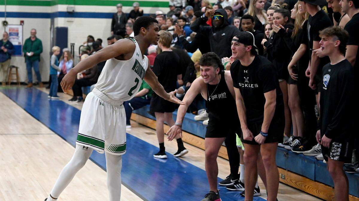 Weddington HighÕs Chase Lowe, left, reaches out to slap hands with fans near the end of action against Mooresville during the second round of NCHSAA action on Thursday, February 24, 2022. Weddington is top a top 25 nationally ranked team. Weddington defeated Mooresville 70-60.
