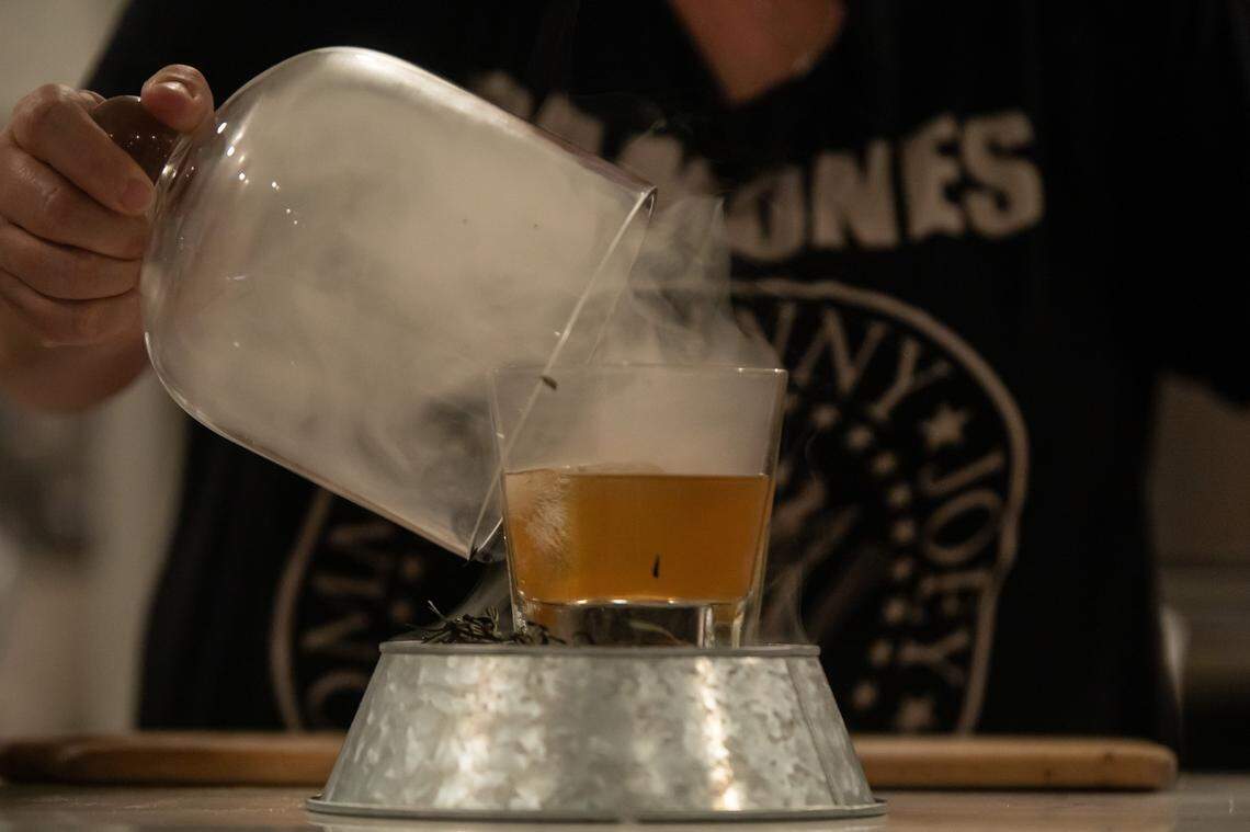 The Paratrooper at The Artisan’s Palate includes housemade Fig Bourbon, rosemary simple syrup, bitters and smoked rosemary.