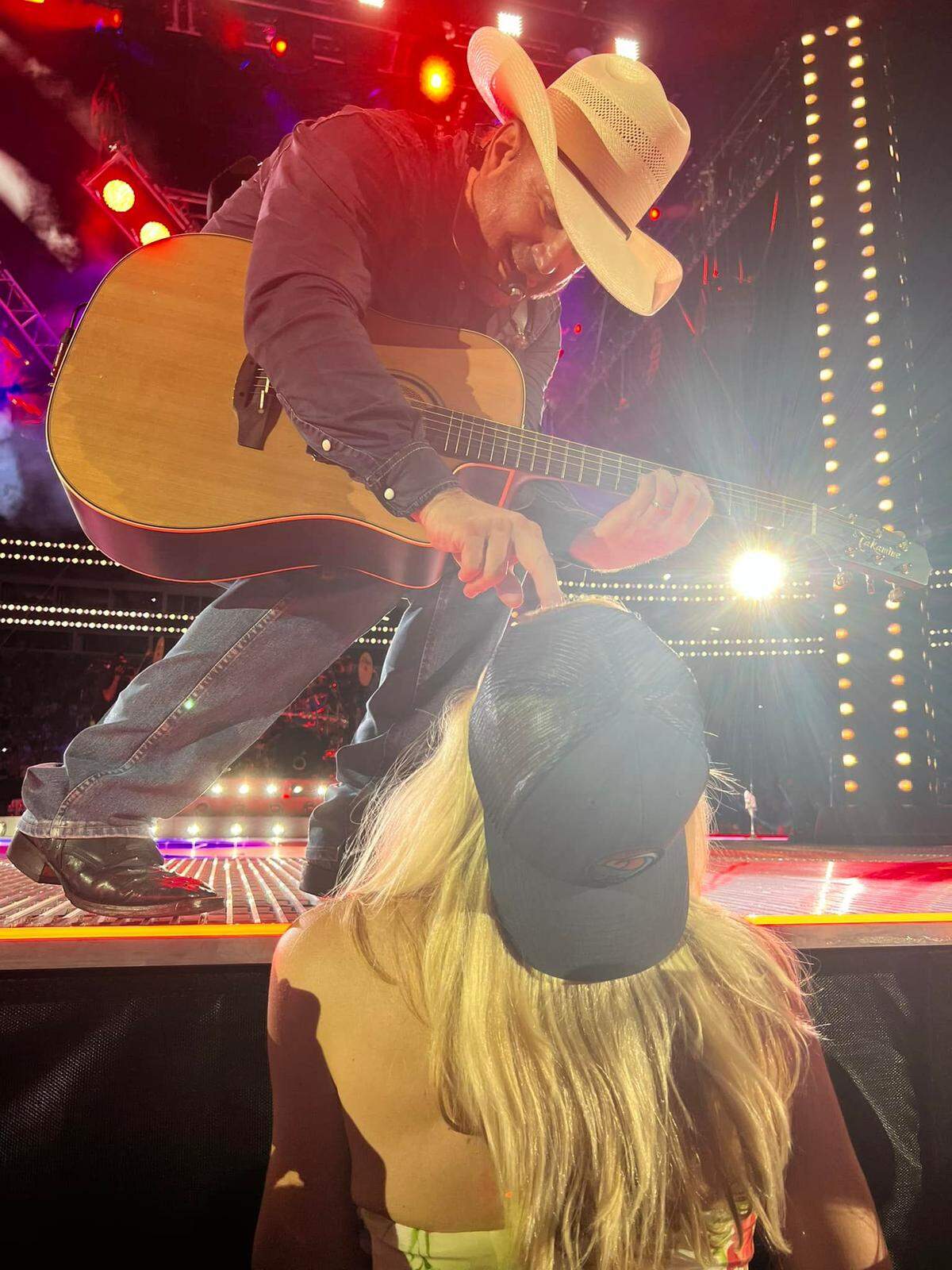 Garth Brooks crouches down to hand Molly Grantham a guitar pick during his show at Bank of America Stadium in Charlotte earlier this month.