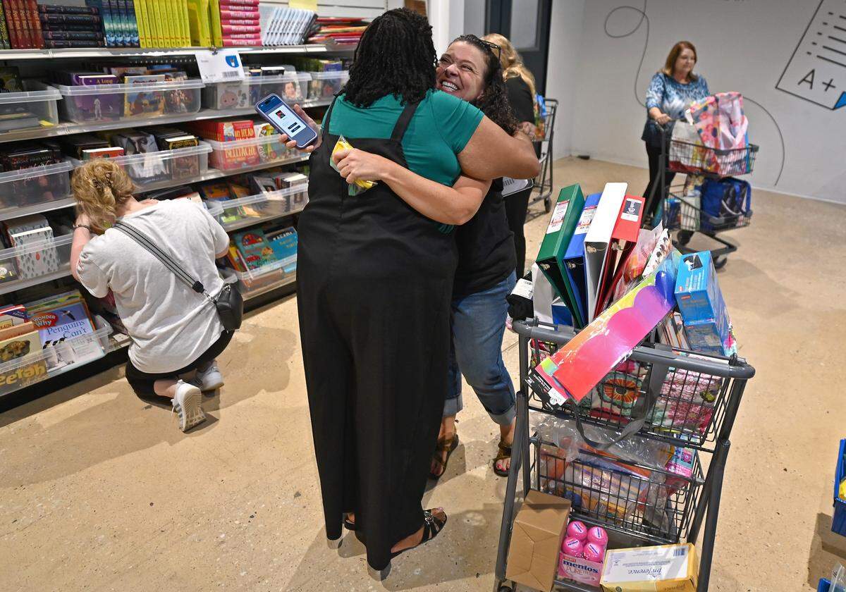 Walter Bickett Elementary School teachers Angela Walker, left/back to camera and Hallie Powers, right, catch up with one another at Classroom Central in Charlotte, NC on Thursday, August 14, 2025. Classroom Central provides free resources ie. school items to local and eligible (Title 1) schools.Walker teaches first grade and Powers teaches Leader in Me and pre-K through fifth grade at Walter Bickett Elementary School in Union County.