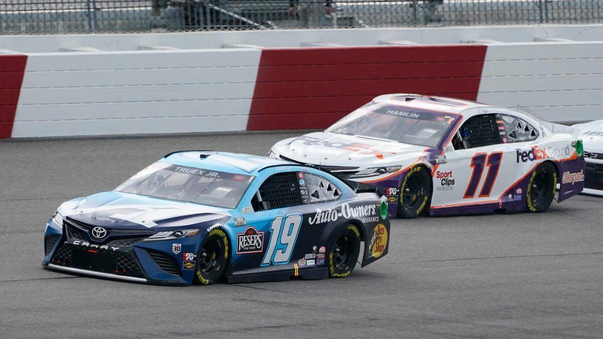 Martin Truex Jr. (19) leads Denny Hamlin (11) at the start of the NASCAR Cup Series auto race at Richmond International Raceway in Richmond, Va., Sunday, April 18, 2021. (AP Photo/Steve Helber)