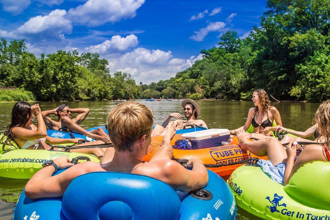 A group of of swimmers tubing in French Broad River in Asheville, NC.