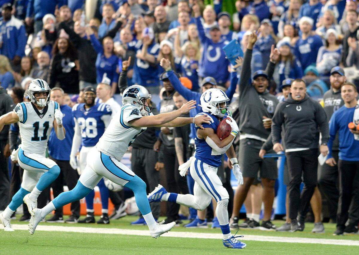 Indianapolis Colts running back Nyheim Hines, right, runs past Carolina Panthers punter Michael Palardy, center, for a touchdown following a punt at Lucas Oil Stadium in Indianapolis, Indiana on Sunday, December 22, 2019.