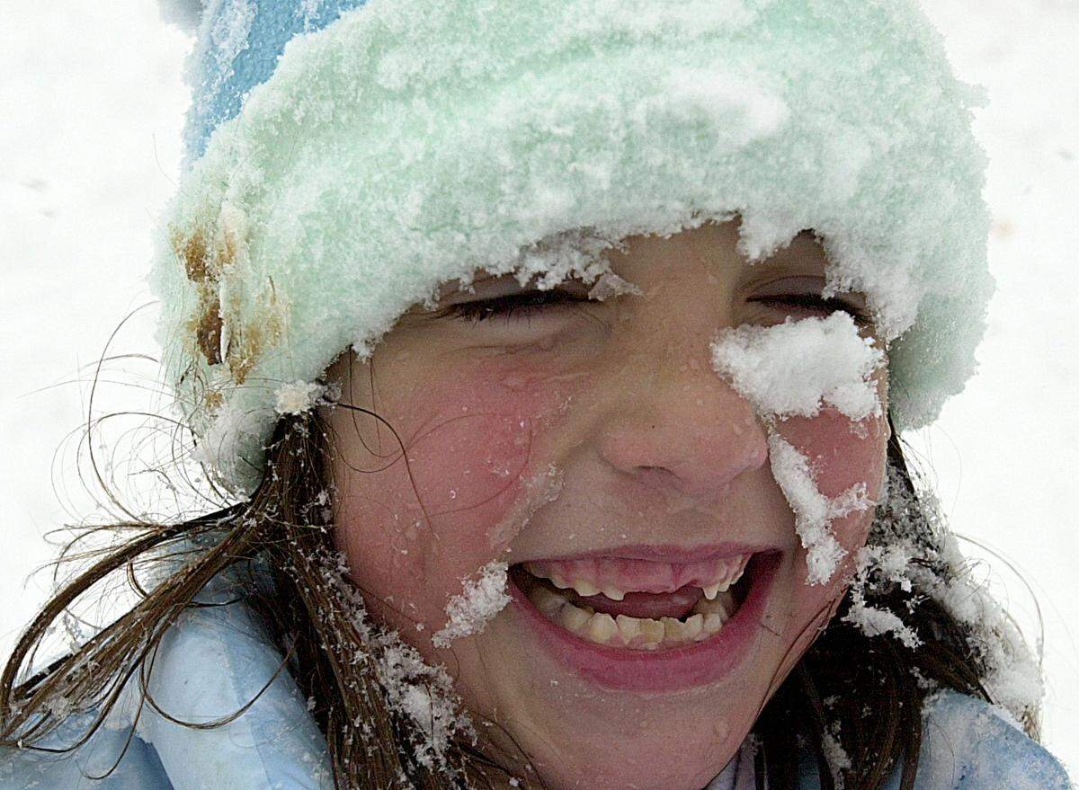 Isa Eugenio, 8, is all smiles Thursday morning despite having snow caked on her rosy cheeks following a snow ball fight with her friend in January 2002,
