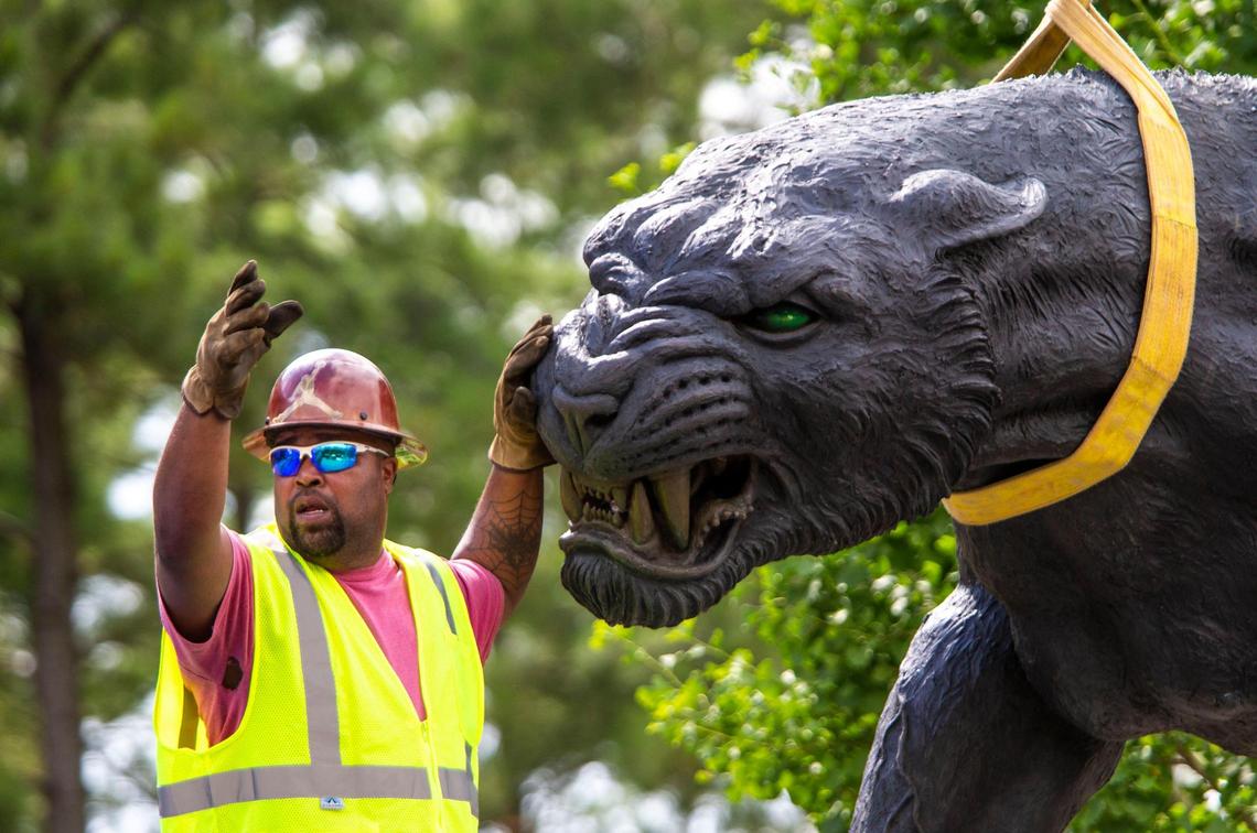 A crewman communicates with the crane operator as they remove the three part statue of Jerry Richard flanked by two panthers in front of the Bank of America Stadium in Charlotte, NC on Wednesday, June 10, 2020. Richardson was the founder and majority owner of the Carolina Panthers team and sold his stake after an NFL investigation substantiated allegations of both sexual and racial misconduct.