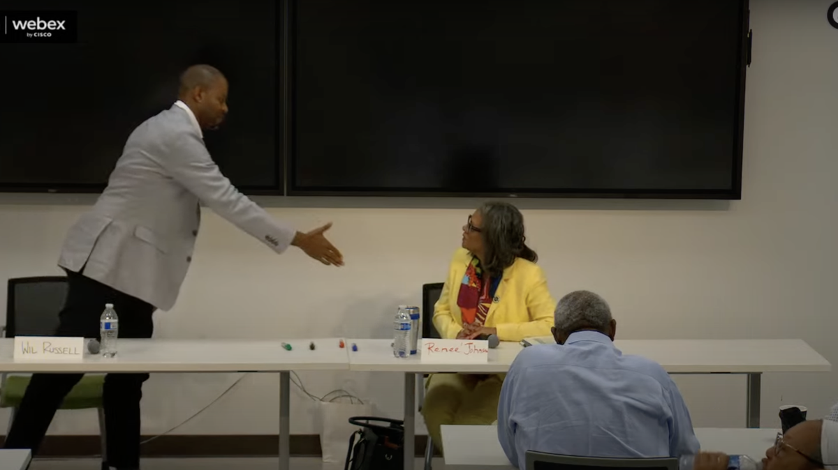 Charlotte City Council District 4 candidate Wil Russell extends his arm to incumbent Renee Perkins Johnson for a handshake after trading criticisms during the Sarah Stevenson Tuesday Forum on Aug. 19, 2025.