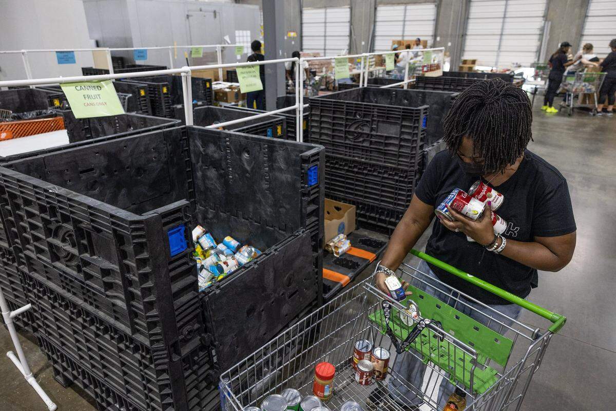 David Patterson sorts canned food at Loaves & Fishes and Friendship Trays in Charlotte on Wednesday, June 8, 2022.