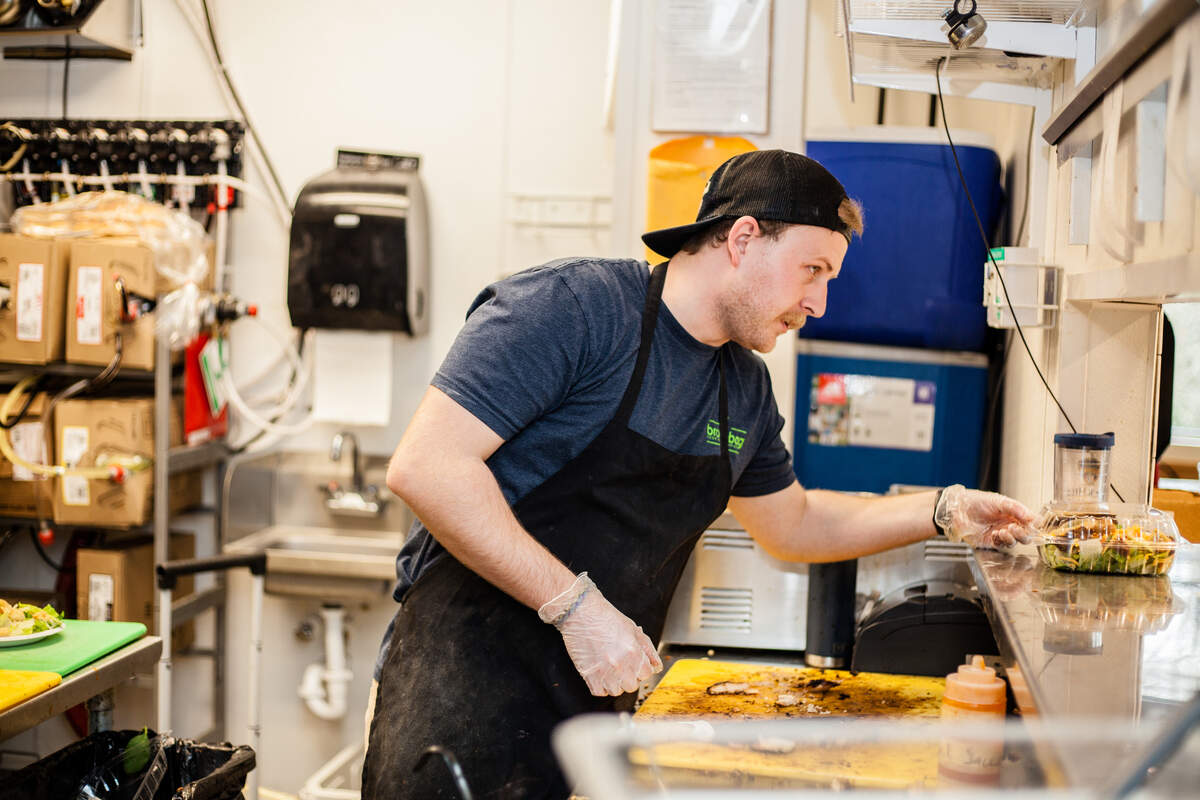 Andrew Howard serves up a salad in the window at Brown Bag.