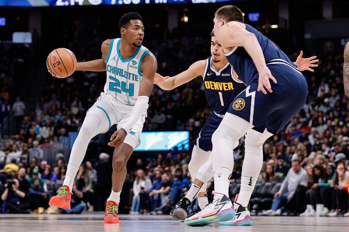 Charlotte Hornets forward Brandon Miller (24) controls the ball against Denver Nuggets forward Michael Porter Jr. (1) and center Nikola Jokic (15) in the first quarter at Ball Arena.