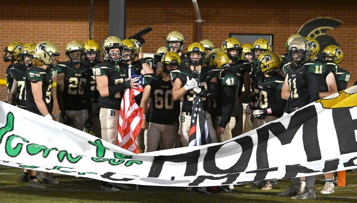 The Bandys Trojans football team gather behind a banner prior to running onto the field to face the Lincolnton Wolves on Thursday, September 29, 2022 at Bandys High School in Catawba, NC.