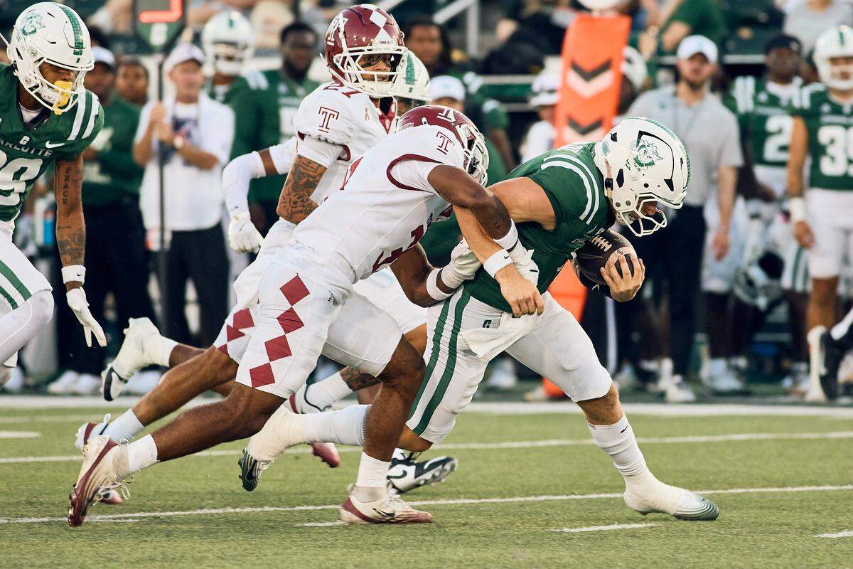 Charlotte 49ers quarterback Zach Wilcke (1) tries to carry defenders late in the game against the Temple Owls at Jerry Richardson Stadium for Homecoming.