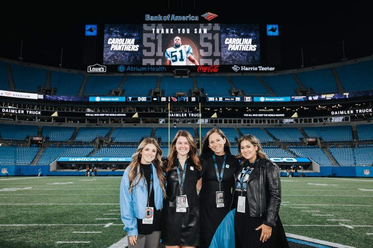 Cameron Hutchinson, the Carolina Panthers’ director of partnerships, poses with colleagues in Bank of America Stadium. Under Dave and Nicole Tepper’s leadership, the percentage of female staff at Tepper Sports and Entertainment has grown year-over-year from 18% to 30%.
