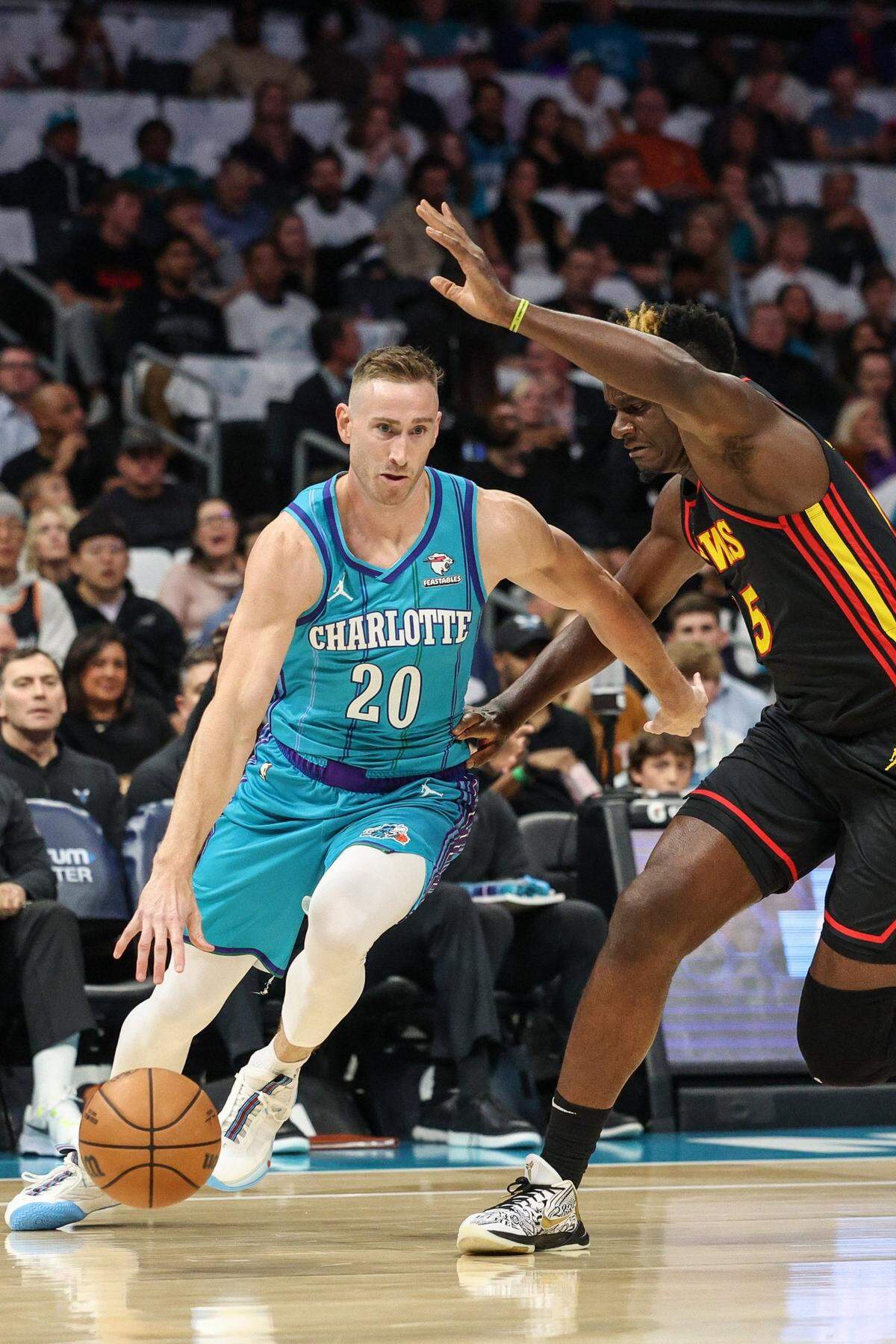 Hornets forward Gordon Hayward, left, drives the ball past Hawks center Clint Capela during the game at Spectrum Center on Wednesday, October 25, 2023.
