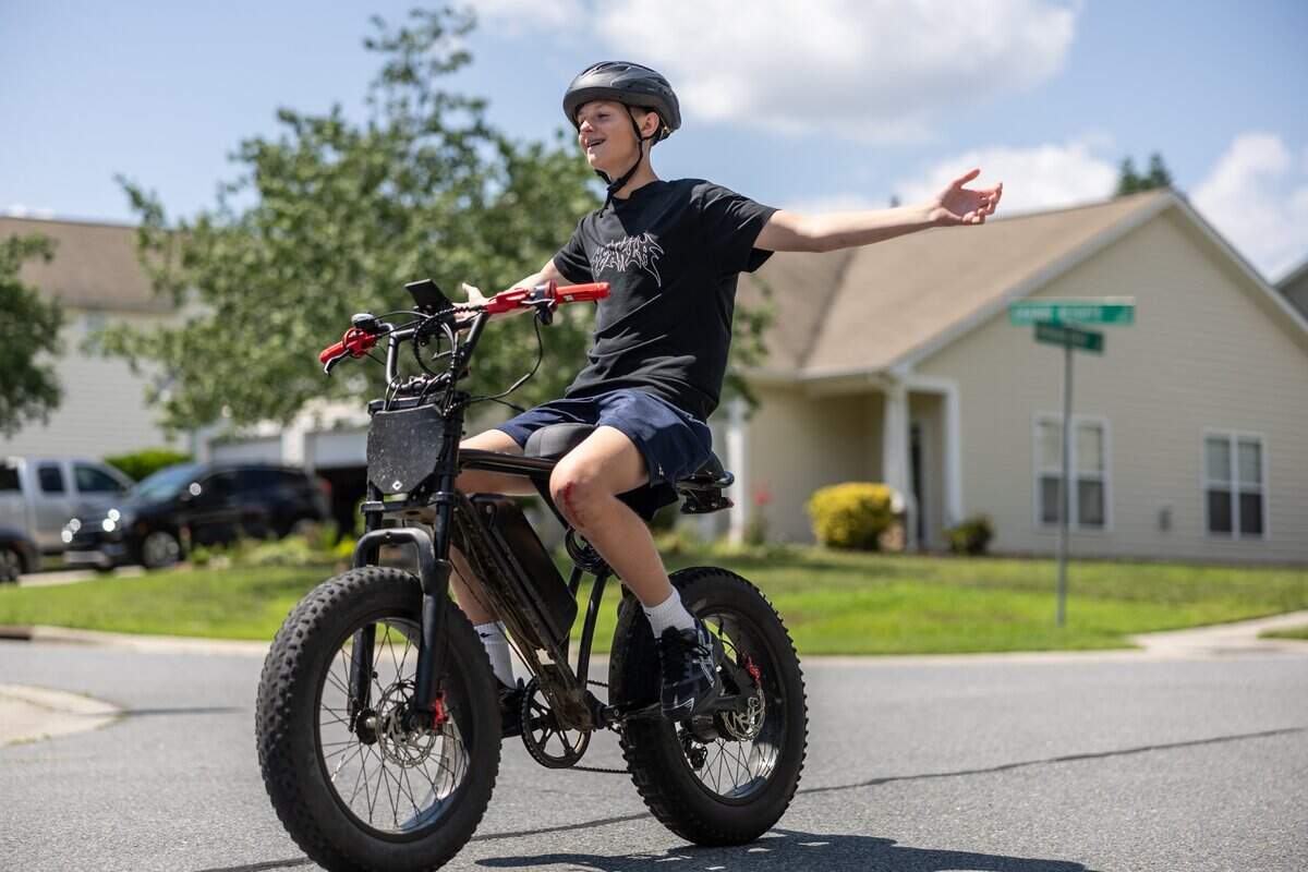 Cam Fuller rides his e-bike around his neighborhood in Charlotte, N.C., on Monday, June 29, 2026.