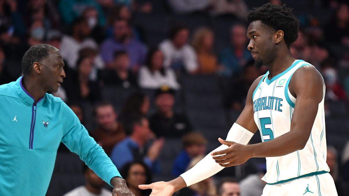 Charlotte Hornets assistant coach Tyrone Corbin, left, reaches out to congratulate center Mark Williams on his play during first half action against the Washington Wizards on Monday, October 10, 2022 at Spectrum Center in Charlotte, NC.