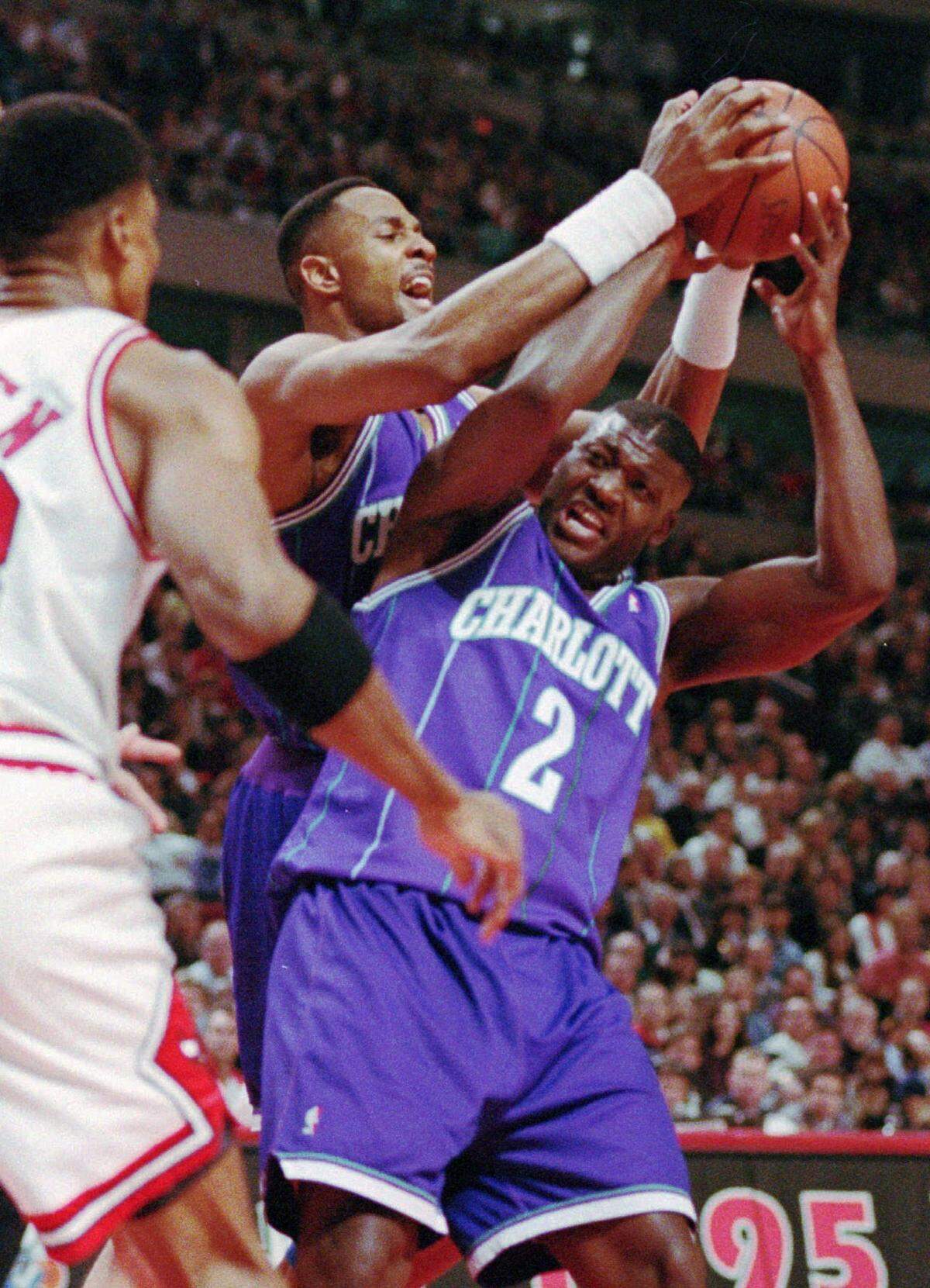 Charlotte Hornets Larry Johnson (2) battle for a rebound Thursday as Chicago’s Scottie Pippen looks on during the first quarter of the Bulls’ 85-84 victory.