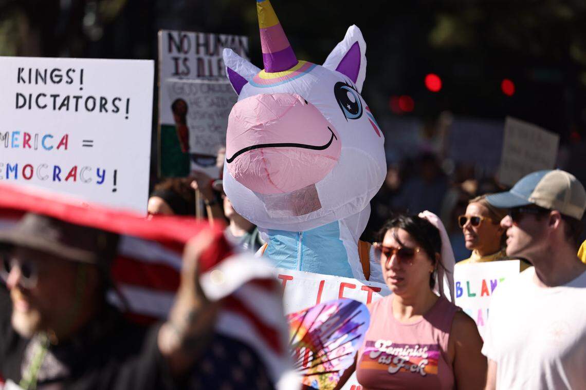 A person in an inflatable unicorn costume watches on during the ‘No Kings’ rally in uptown Charlotte on Saturday, Oct. 18.