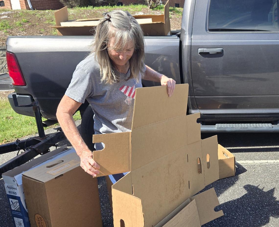 Volunteer Julie Cardenas breaks down boxes after meals were sent by Cracker Barrel to serve at the Oak Hill Methodist Church.