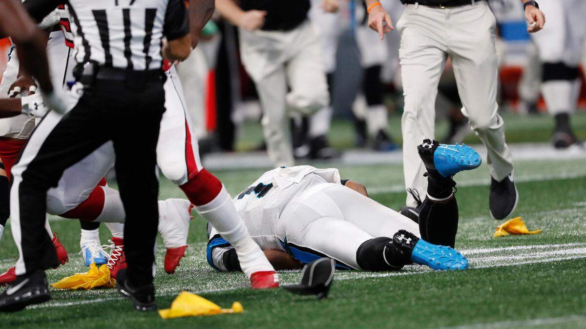 Carolina Panthers quarterback Cam Newton (1) stays down on the turf after being hit by Atlanta Falcons cornerback Damontae Kazee (27) during the first half on Sunday in Atlanta. Kazee was ejected from the game after the hit.