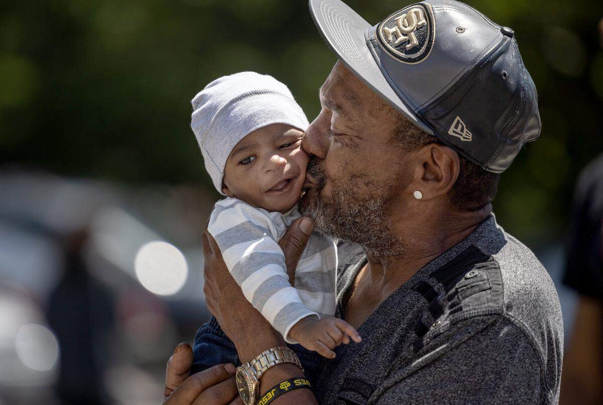 John Clay kisses his grandson, John Clay III, 5 months, while they wait in line for free baby formula at StarMed Healthcare in Charlotte, N.C., on Tuesday, May 17, 2022. “The last time we found formula was a month ago, I don’t know what we would’ve done without it. You can’t just feed him anything, he’s just a baby.” said John.