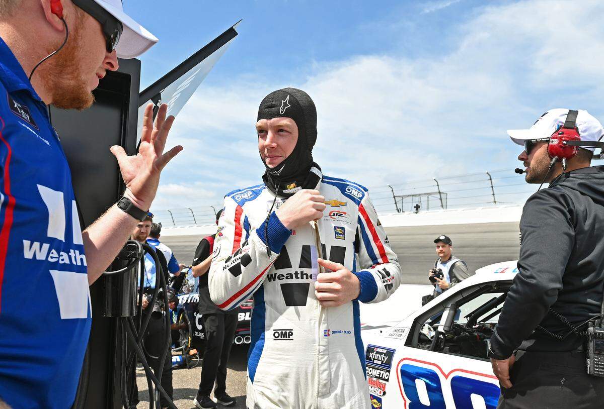 NASCAR Xfinity Series driver Connor Zilisch, center, receives information from a crewman prior to qualifying at Rockingham Speedway for the North Carolina Education Lottery 250 on Saturday, April 19, 2025.