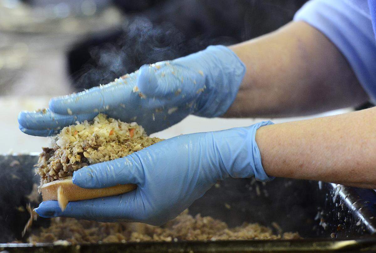 Steam rises from a pulled pork sandwich, topped with cole slaw, freshly made by Michel Lapalombella on Thursday Oct. 24, 2013 at the 84th annual Mallard Creek Barbecue. 