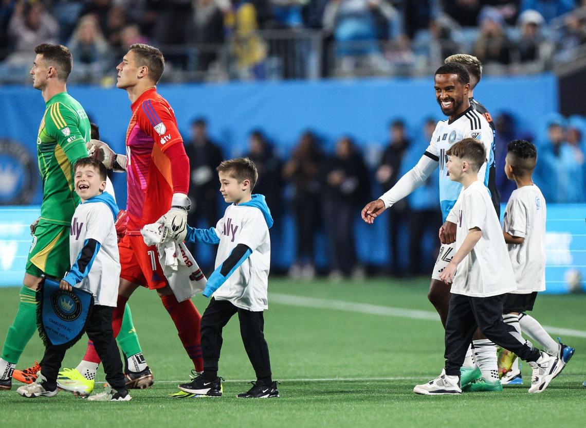Charlotte FC players are escorted onto the pitch by child mascots before their match against New York City FC at Bank of America Stadium in Charlotte, NC on February 24, 2024.