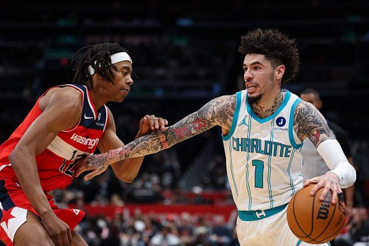 LaMelo Ball #1 of the Charlotte Hornets drives to the basket against Tre Johnson #12 of the Washington Wizards during the first half at Capital One Arena on October 26, 2025 in Washington, DC.