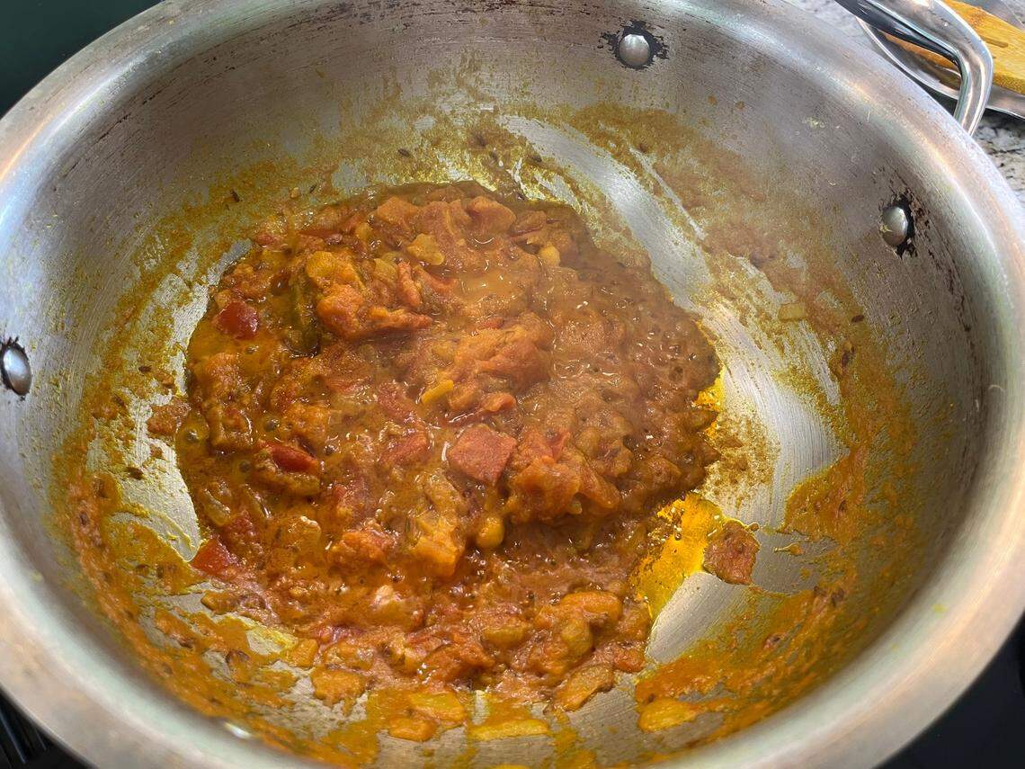 When oil starts to pool at the edges of the masala sauce, it has finished cooking. You can then mix it into the chicken and vegetable mixture and add heavy whipping cream to finish the dish.