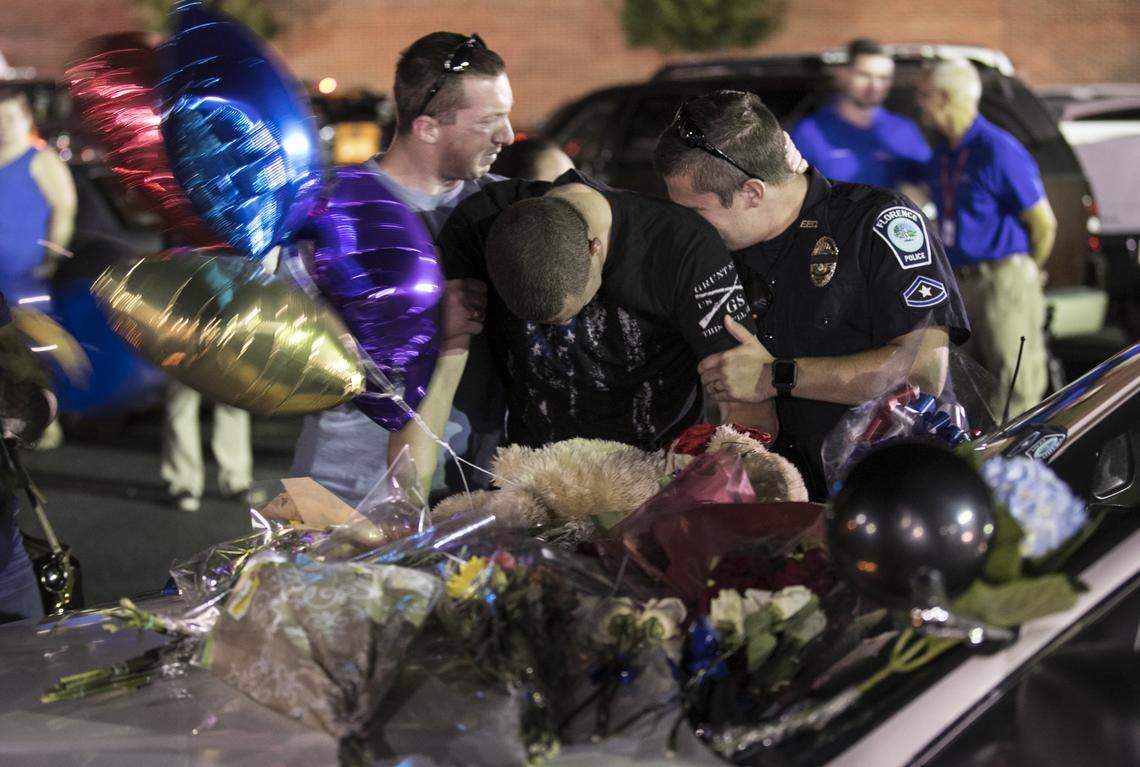 Florence police officers mourn at a makeshift memorial following a candlelight vigil for Sgt. Terrence Carraway who was killed in the line of duty on Wednesday.