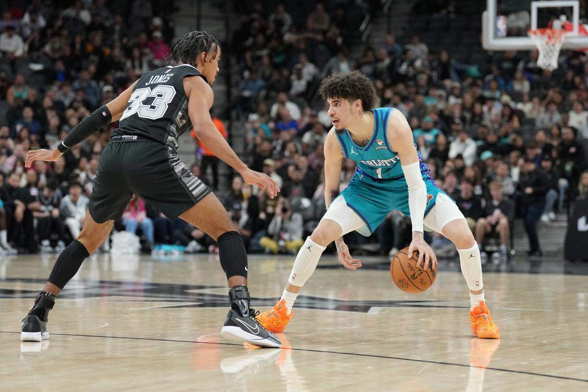Charlotte Hornets guard LaMelo Ball (1) dribbles against San Antonio Spurs guard Tre Jones (33) in the first half at Frost Bank Center.