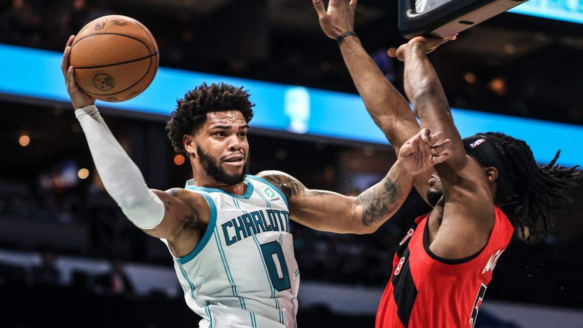 Charlotte Hornets Miles Bridges, left, passes past Toronto Raptors Precious Achiuwa at the Spectrum Center In Charlotte, N.C., on Monday, February 7, 2022.
