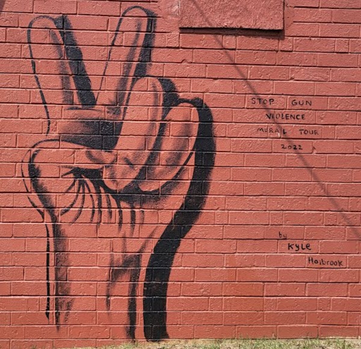Kyle Holbrook painted “Peace Charlotte” on the side of a store on Parkwood Avenue in Charlotte, NC, as part of a national mural tour that calls for an end to gun violence.