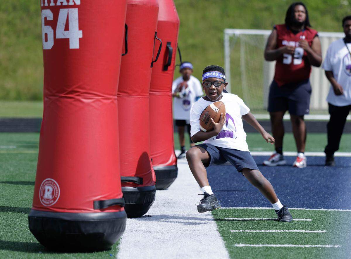A young camper goes through the cones during NFL player Trent Simpson’s free camp at his alma mater, Mallard Creek High School, Saturday