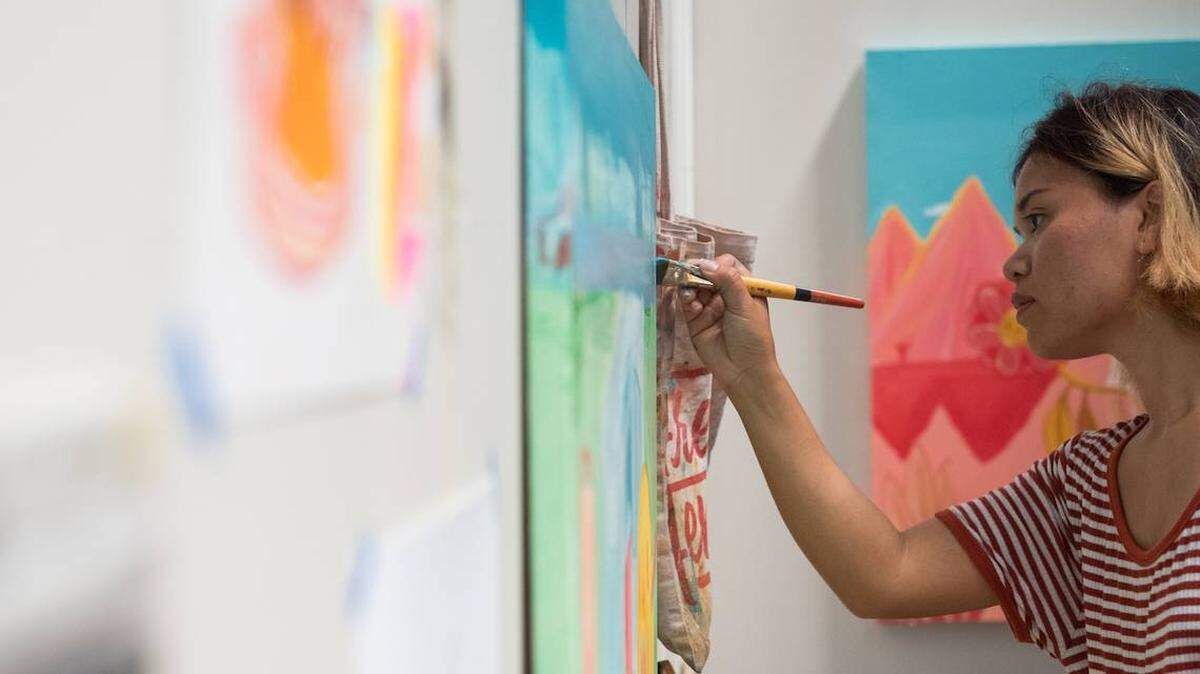 Artist HNin Nie paints at The Goodyear House in this file photo. Nie is one of eight artists creating murals at the fourth annual Talking Walls Festival in Oct. 2021.