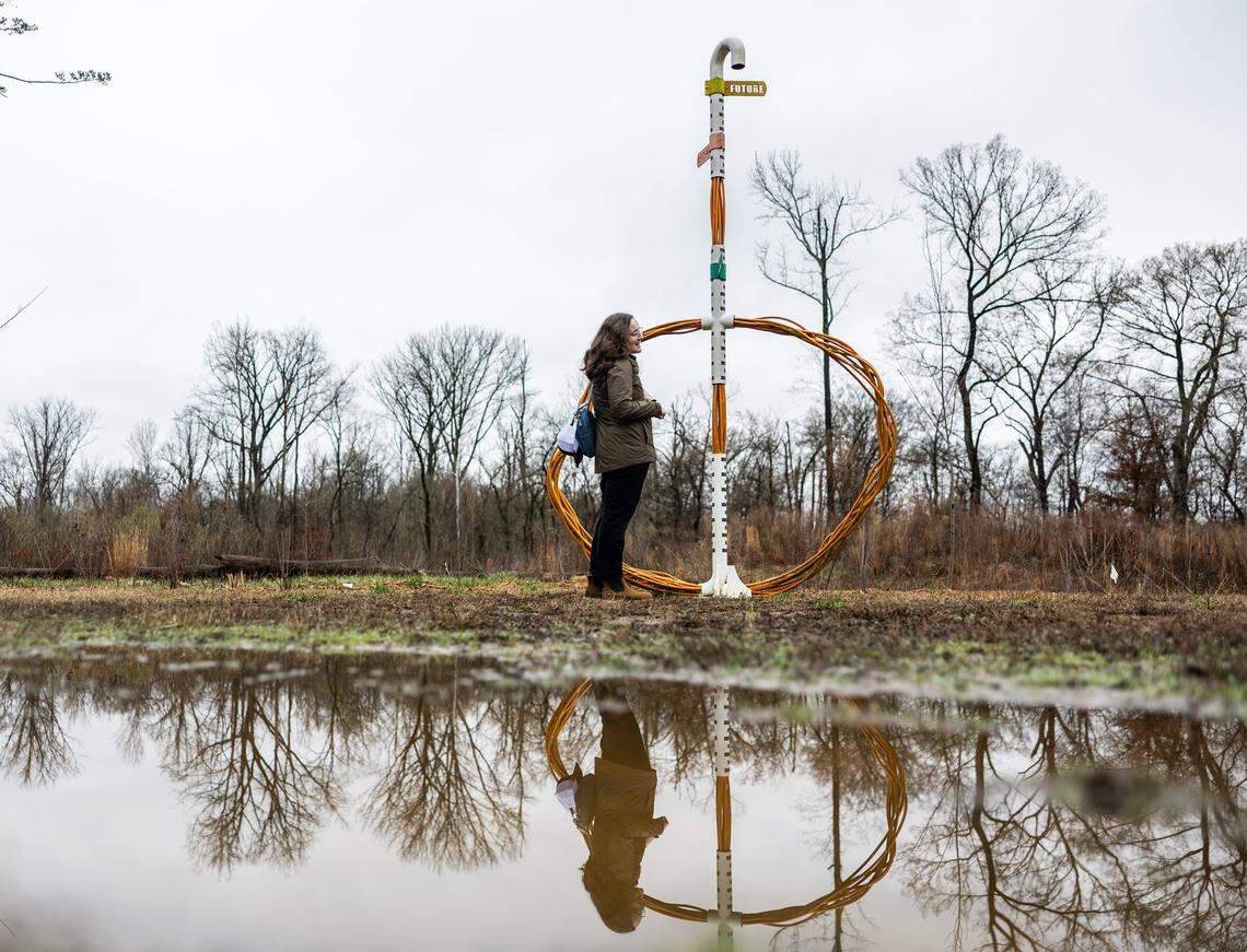Corinne Rizzo, spokesperson for Charlotte-Mecklenburg Storm Water Services, stands next to “Diver, A Flood Marker” a sculpture that signifies flood risks, by Charlotte artist Marek Ranis, along Mallard Creek in Charlotte, N.C., on Friday, February 27, 2026.