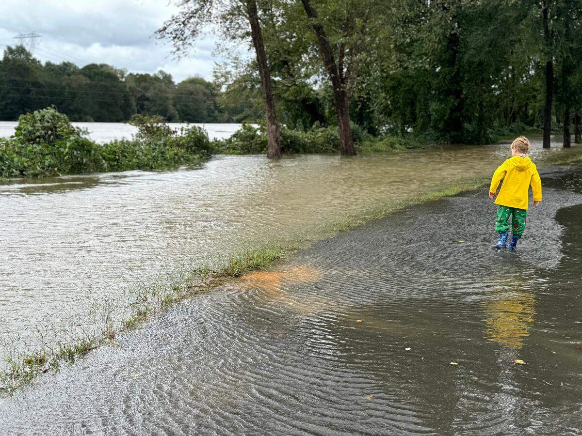 7-year-old Harlan Culberson walks along a flooded path beside the Catawba River Friday as the river overflowed its banks.