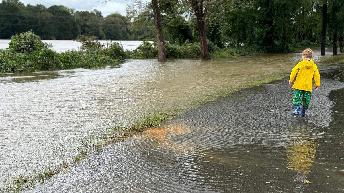 7-year-old Harlan Culberson walks along a flooded path beside the Catawba River Friday as the river overflowed its banks.