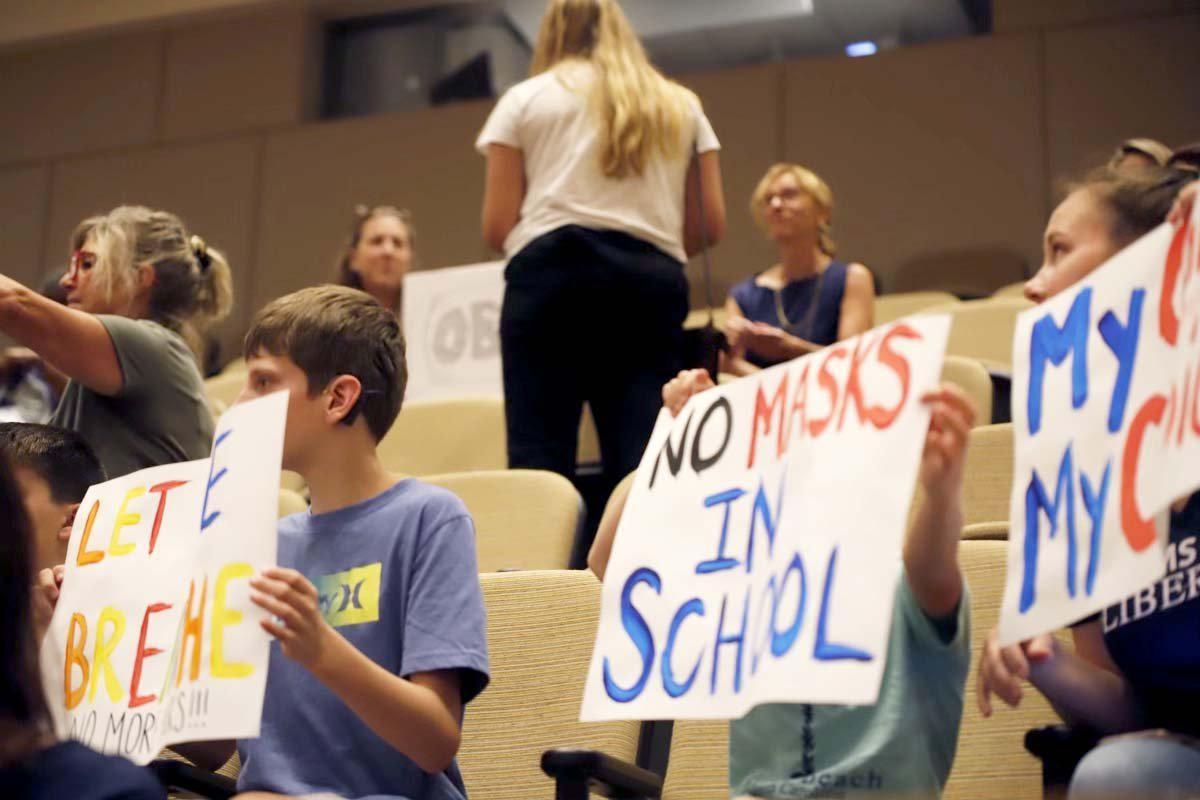 People show up with signs at the Charlotte-Mecklenburg school meeting on Friday, July 30, 2021. The board approved a recommendation to require face masks for all students and staff when classes start next month. CMS will be one of the few local districts to do so.