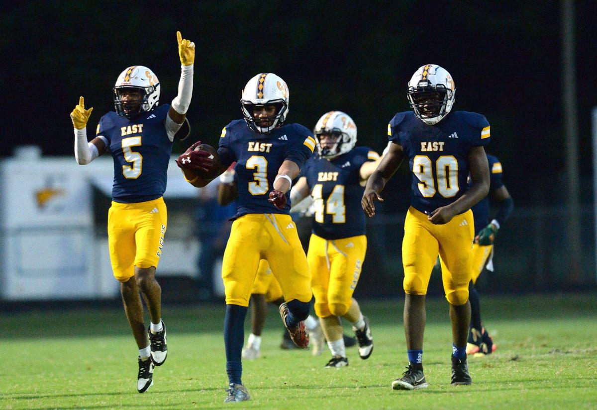 East Meck’s #3, James Bailey leads a phalanx of teammates as they rejoice his interception late in the first half. The Garinger Wildcats (0-4) traveled to face-off on the gridiron against the East Mecklenburg Eagles (0-5) on Monday, Sept. 30, 2024. East Mecklenburg lead 19-0 at halftime.