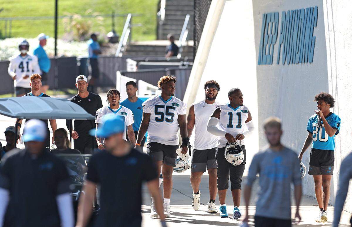 Members of the Carolina Panthers team and personnel walk to training camp practice on July 23, 2025.