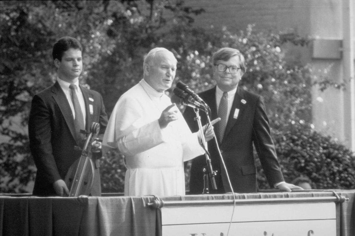 James Holderman with Pope John Paul II on a visit to the University of South Carolina. On the left, the student body president presenting a dulcimer as a gift from the university.