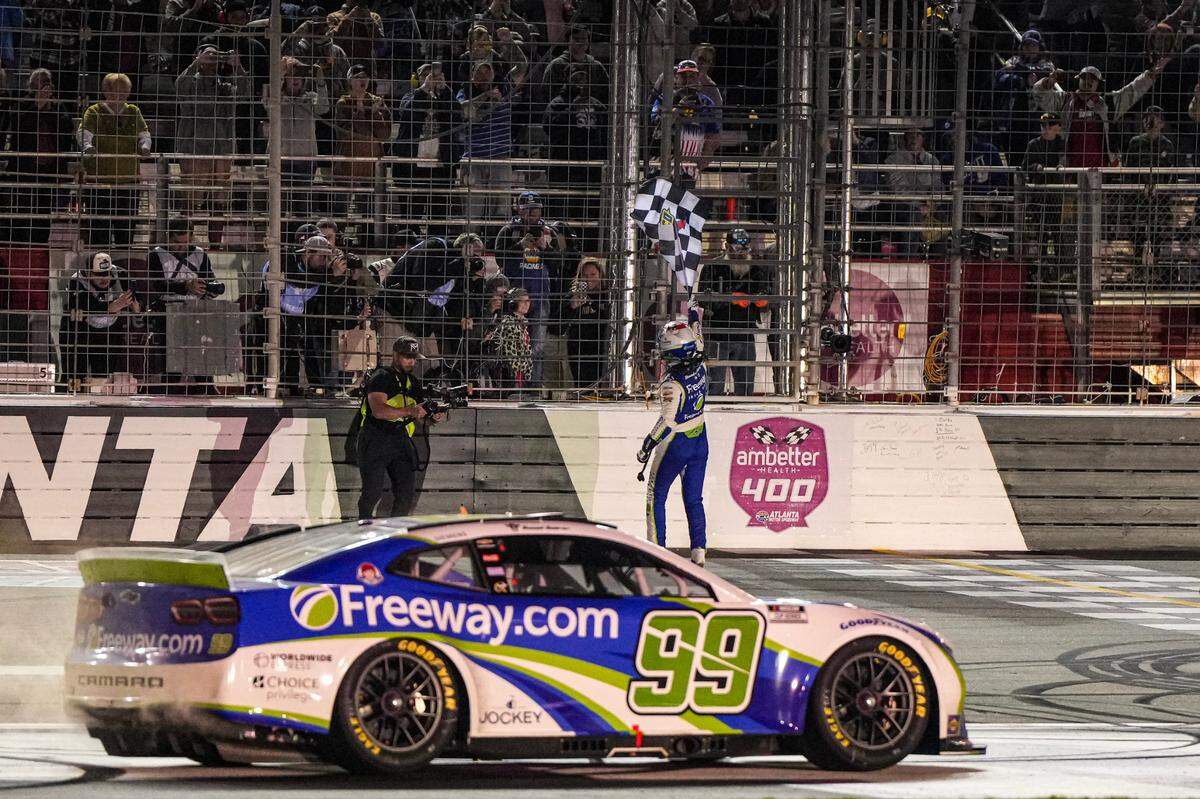 Daniel Suarez (99) celebrates after taking the checkered flag in the Ambetter Health 400 at Atlanta Motor Speedway.