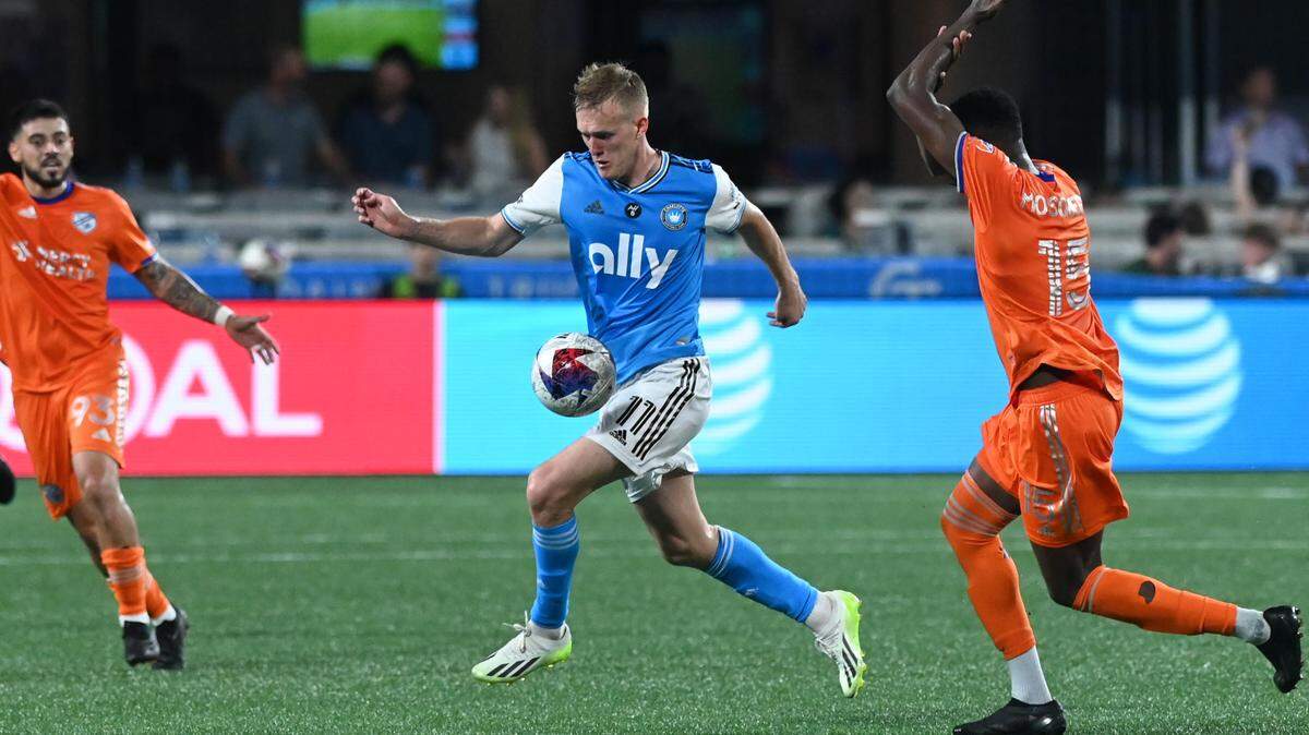 Charlotte FC attacker Karol Swiderski (11) collects the ball as FC Cincinnati defender Yerson Mosquera (15) calls for a hand ball in the second half at Bank of America Stadium.