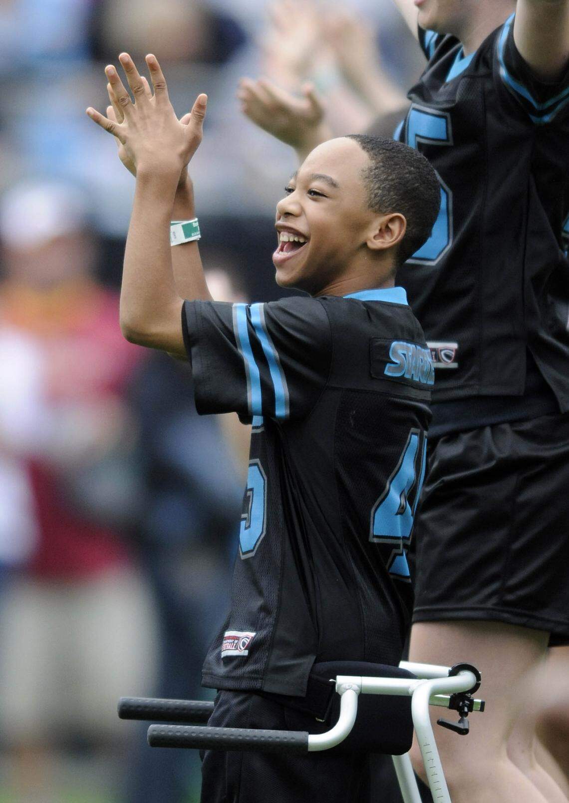 A young Chancellor Lee Adams claps while performing with the Allegro Foundation dance group as part of a Panthers pregame show at Bank of America Stadium in 2009.