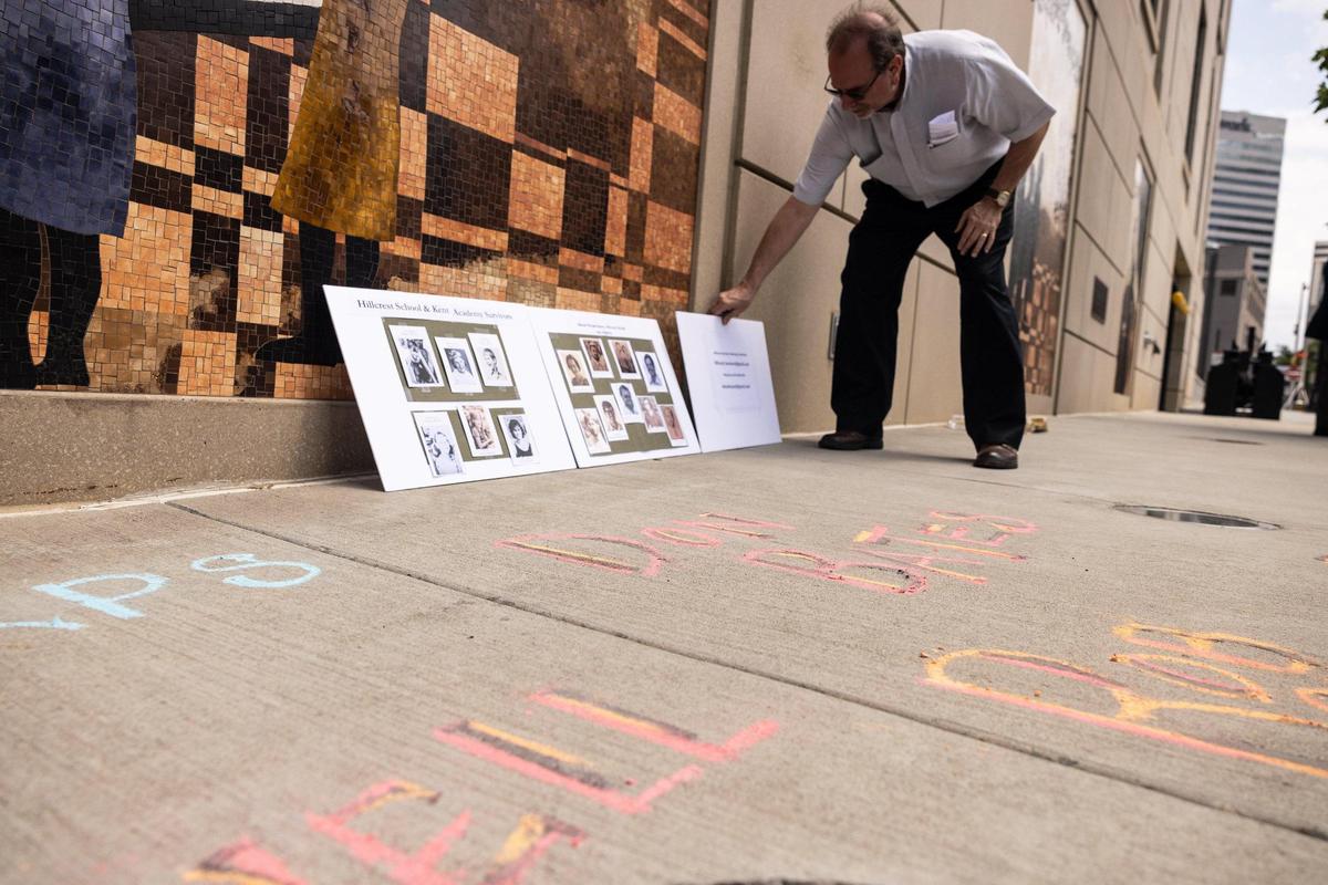 Pastor Rich Darr puts down signs outside of the Charles R. Jonas courthouse in Charlotte, N.C., on Monday, August 15, 2022. Clergy sex abuse victims and advocates disclosed that a Charlotte judge has just tossed out a civil suit against a Charlotte-based Protestant religious group.