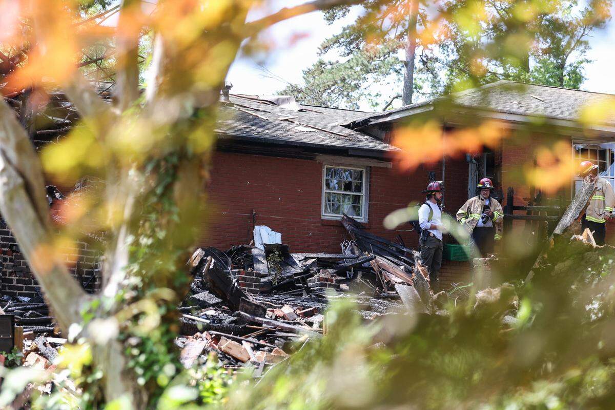 Charlotte Fire Department officials work at the site of a house fire near Freedom Park after an explosion was reported early morning in Charlotte, NC on Friday, May 2, 2025.